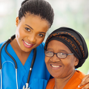 A woman and a nurse smiling for the camera.