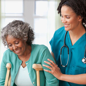 A nurse and an older woman are smiling.